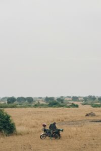 Uganda 2025, paesaggio di savana con motociclista solitario nella natura selvaggia – Viaggi Over 55