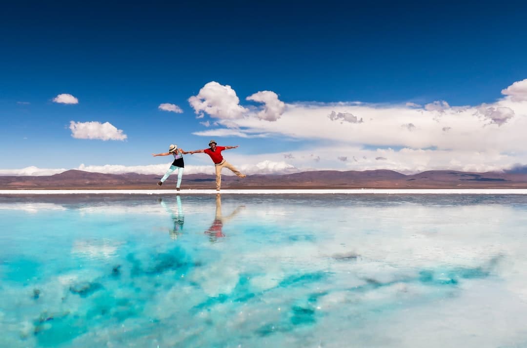 Photo by Hector Ramon Perez woman in black bikini standing on blue water under blue sky during daytime