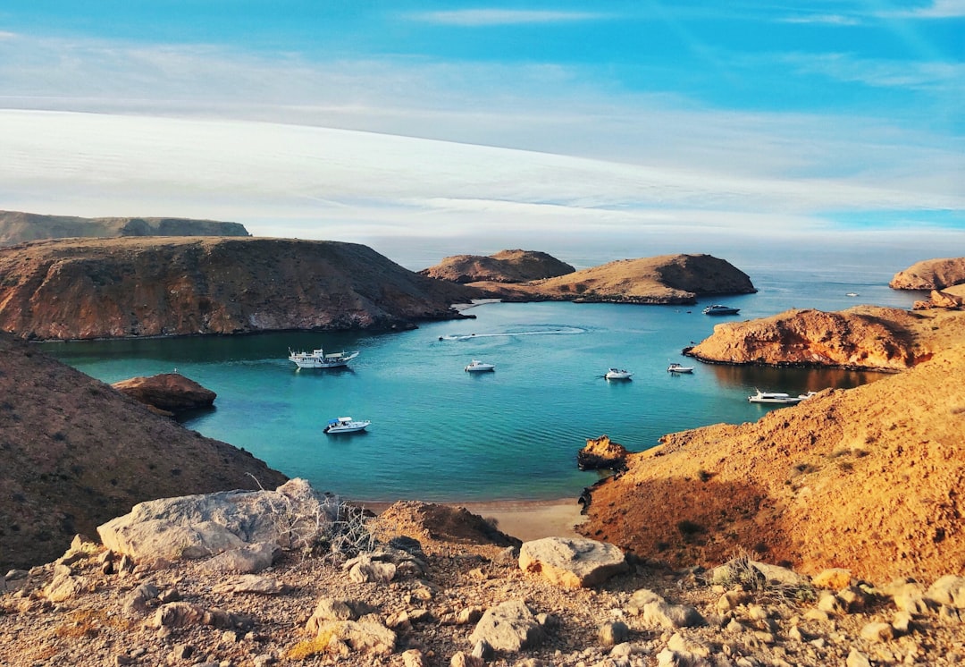 Photo by Katerina Kerdi brown and green rock formation on blue sea under blue sky during daytime