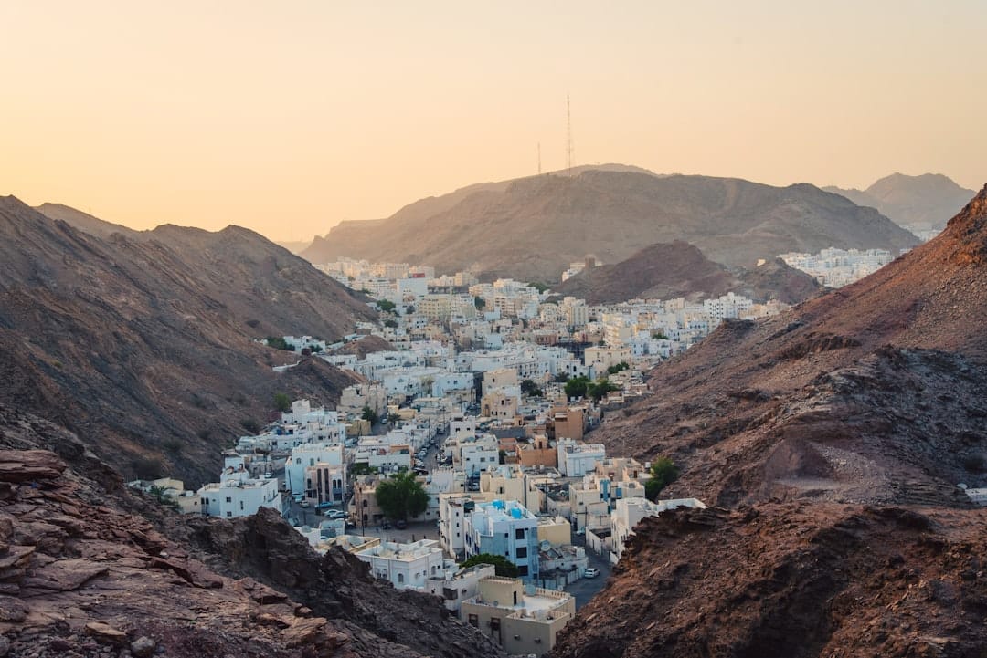 Photo by Anfal Shamsudeen aerial view of white concrete buildings near rock cliffs