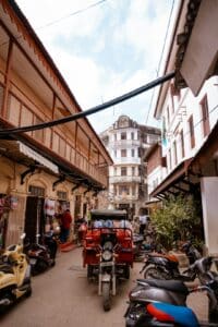 Zanzibar 2025, vicolo animato di Stone Town con motorini e architettura swahili – Viaggi Over 55