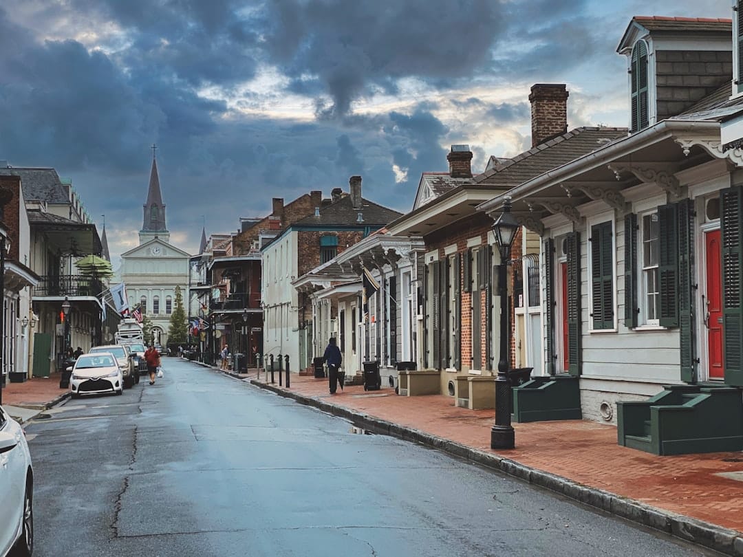 Photo by Nick Agee a street lined with row houses under a cloudy sky