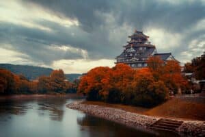 a large building sitting on top of a hill next to a river