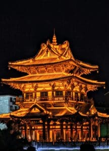 A tall building lit up at night in a city