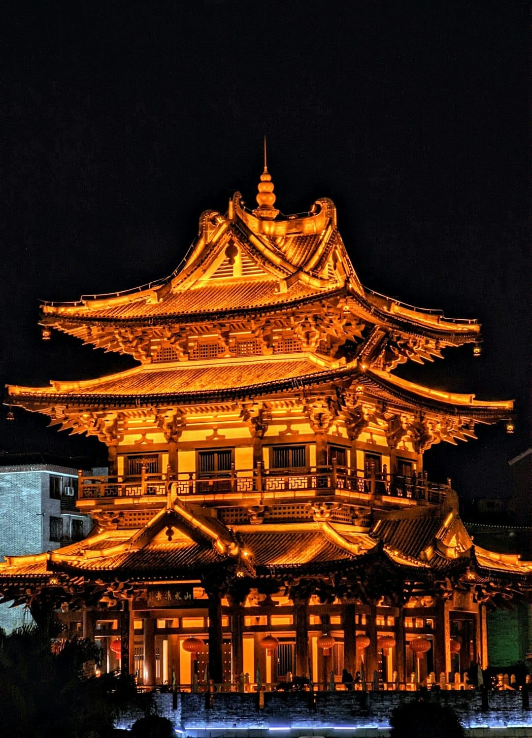 A tall building lit up at night in a city